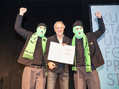 Übergabe Urkunde an Preisträger Kollektiv Gukubimato, Stadtrat Günter Riegler